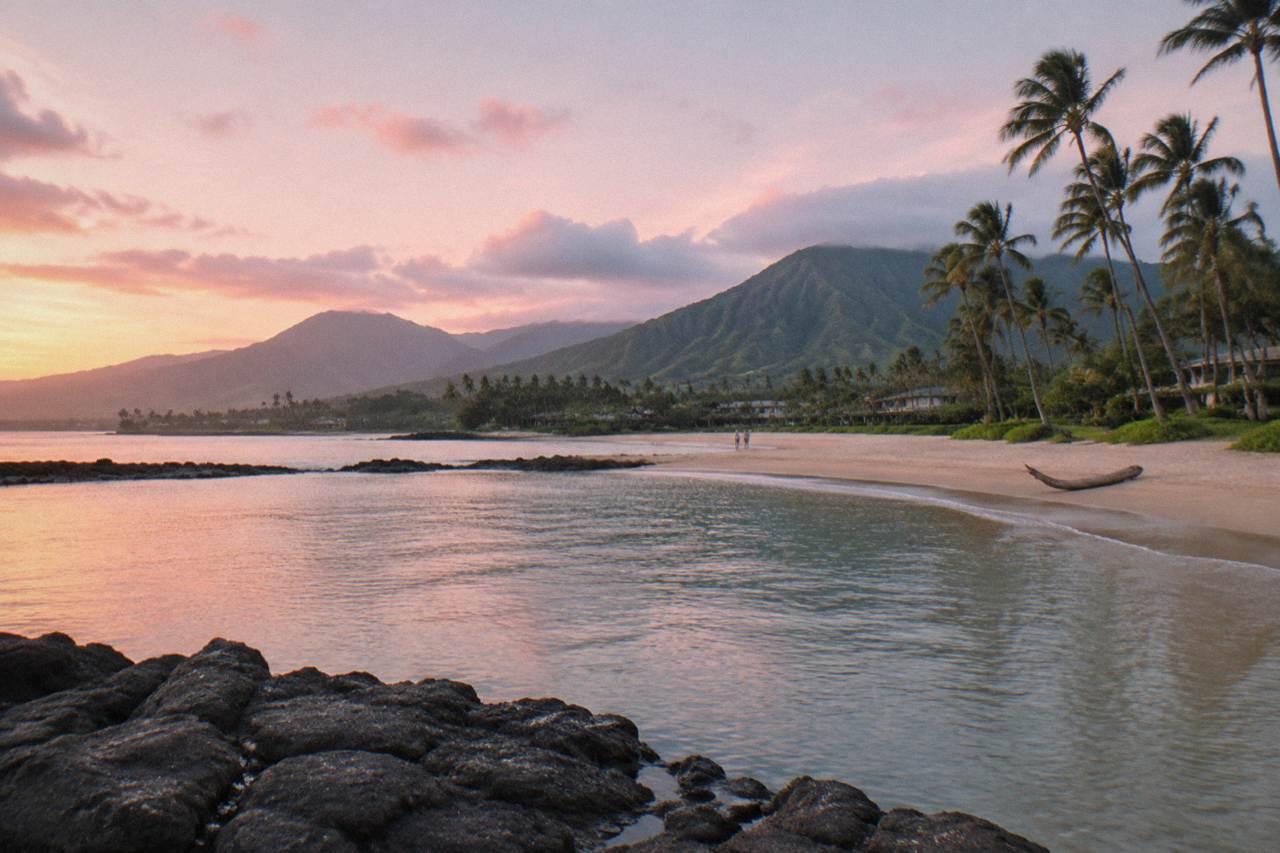 A calm bay on Kauai with green ridges rising behind the shoreline
