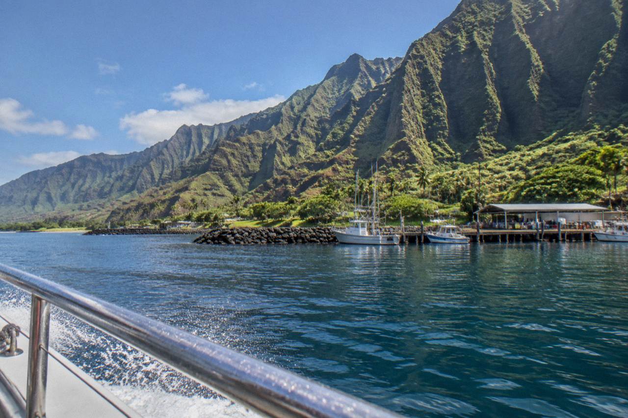 The ridged green cliffs of the Na Pali Coast rising above calm Pacific water