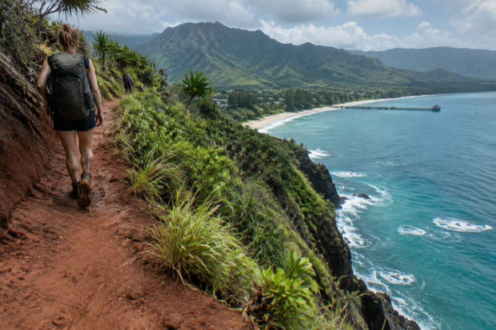 A rugged coastal footpath tracing the edge of emerald sea cliffs above turquoise water