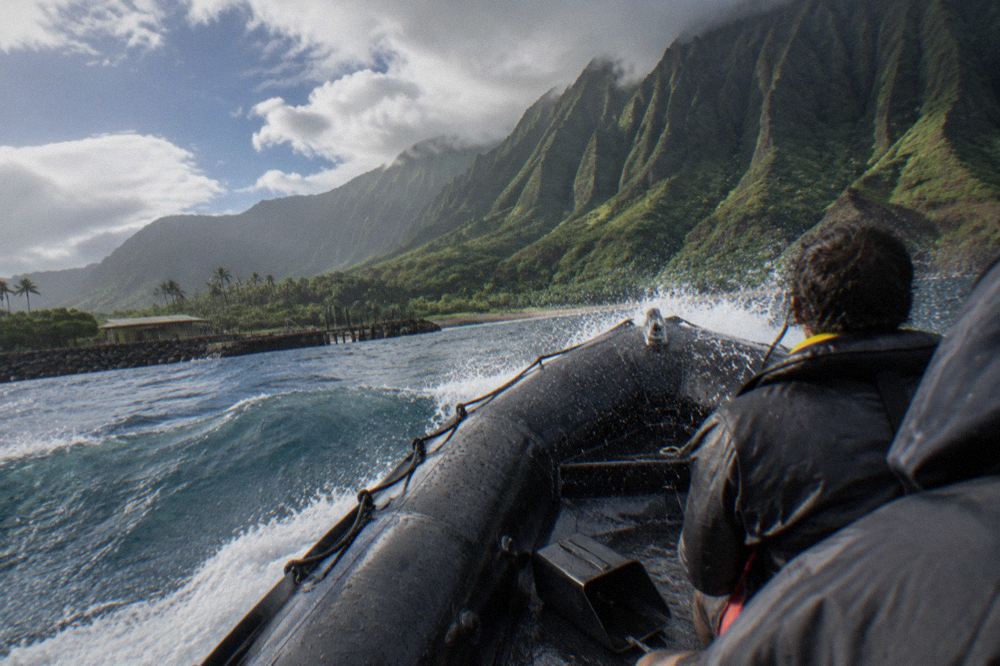 Inflatable raft speeding across open water with spray coming over the bow