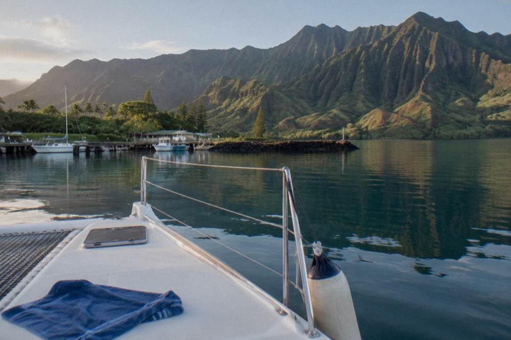 Calm morning ocean along the Na Pali coast with green ridges rising above still water