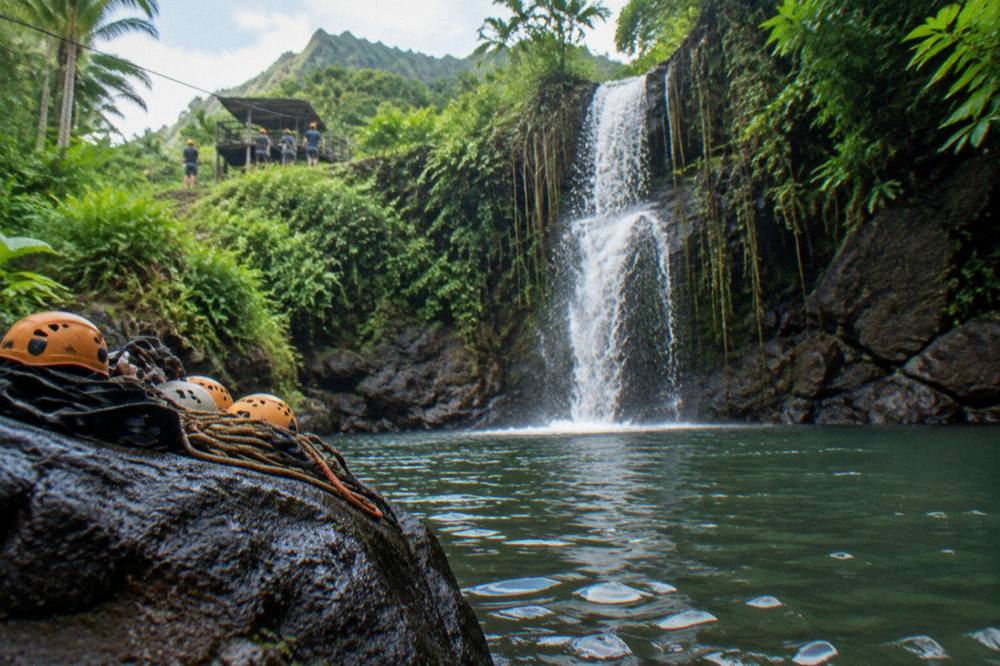 A waterfall dropping into a clear jungle pool surrounded by dark rock and greenery