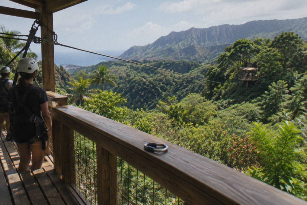 A zipline platform built into a tree line above a jungle valley