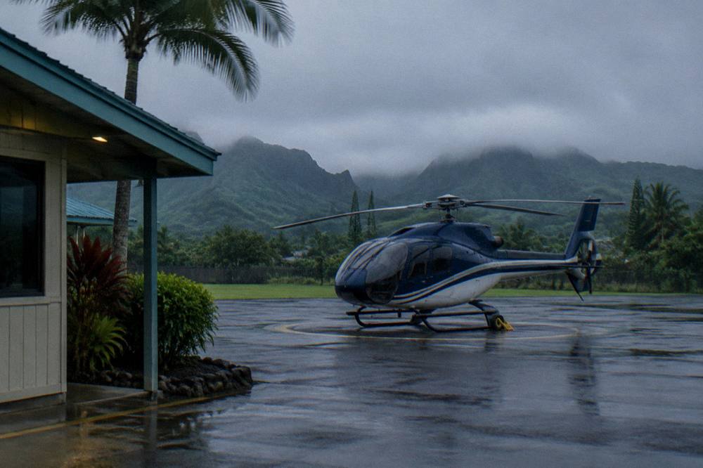 Morning light over a helicopter waiting on a pad with mountains behind