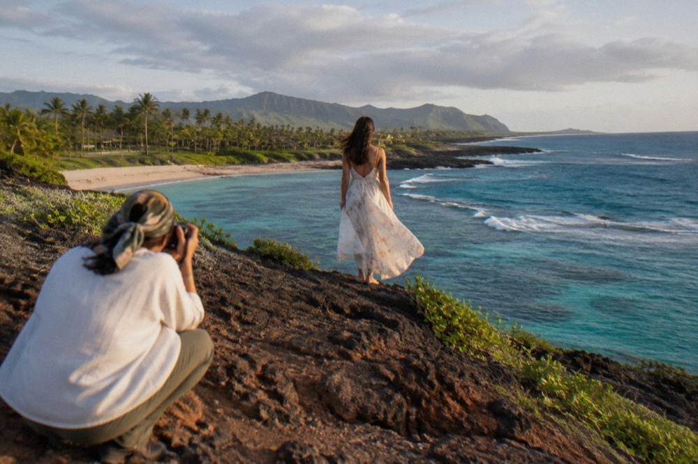 A long flowing dress catching the wind on a coastal bluff above turquoise water