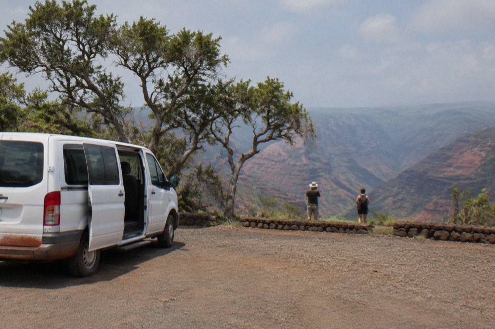 A tour van parked at a coastal overlook on Kauai