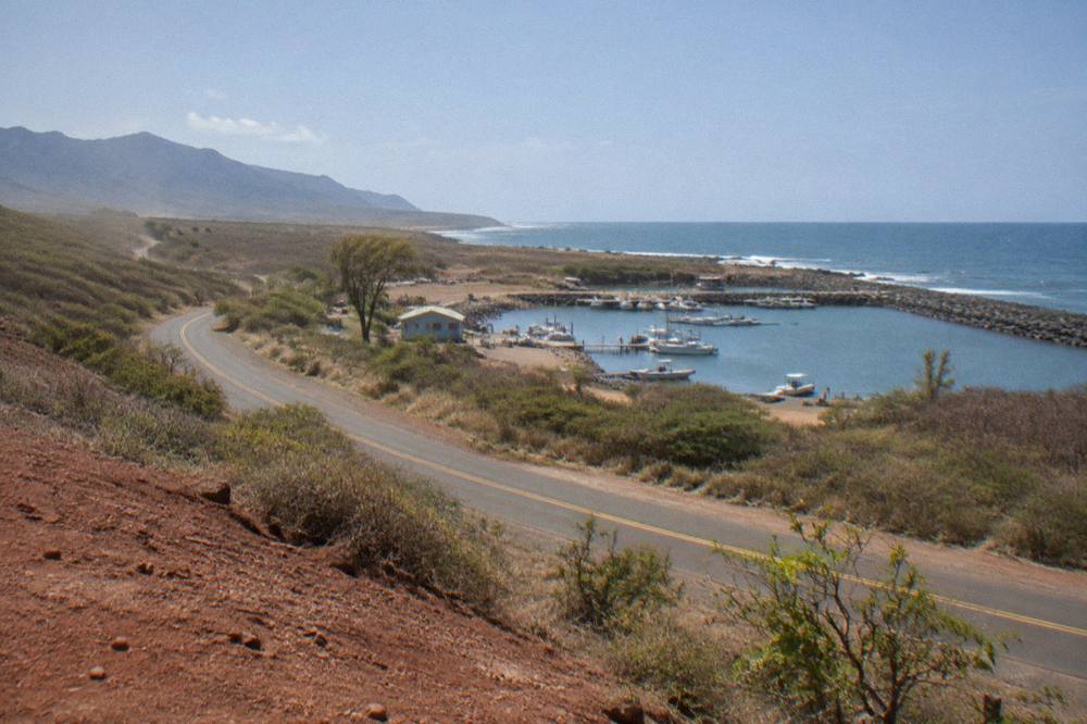 A scenic two-lane road curving along the Kauai coastline