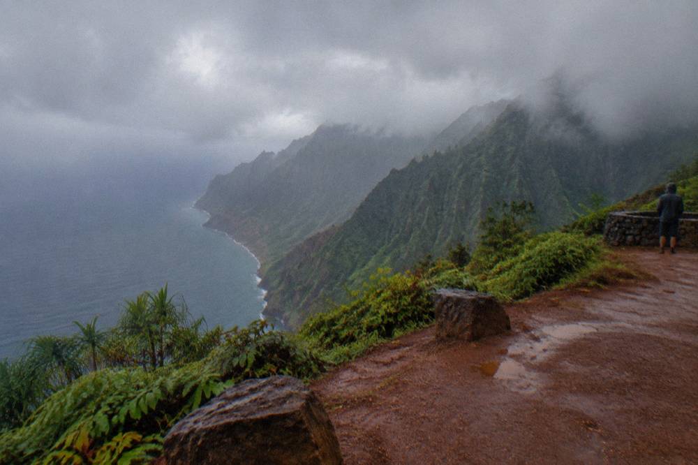 Low clouds and rain shrouding sea cliffs along a rugged coastline.