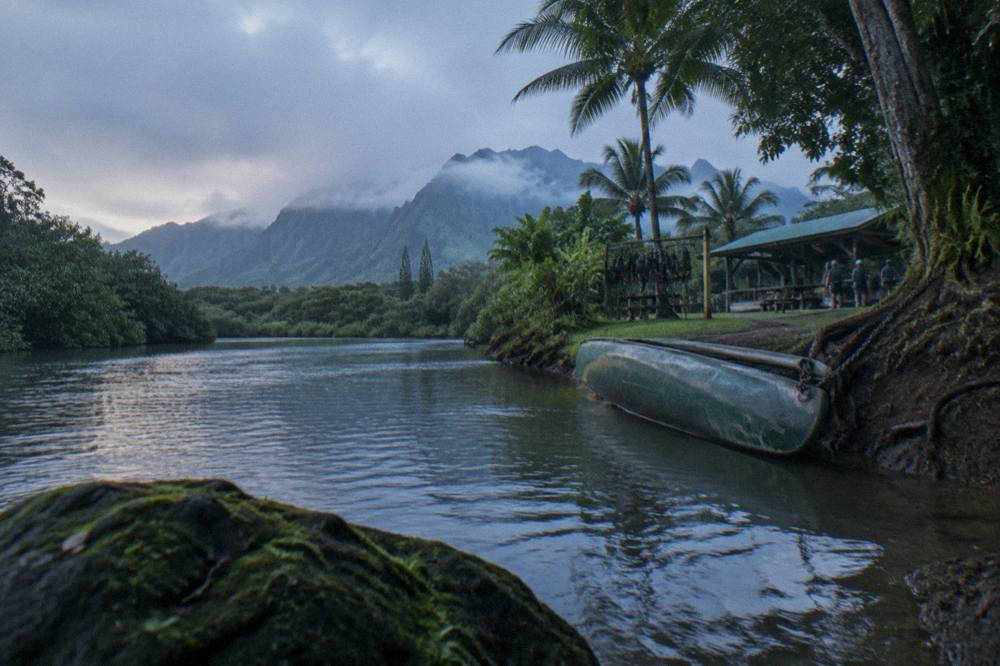 A calm river winding through dense green jungle toward distant volcanic ridges