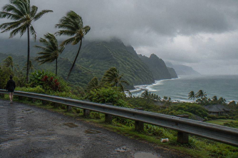 Rain clouds passing over green coastal cliffs on Kauai