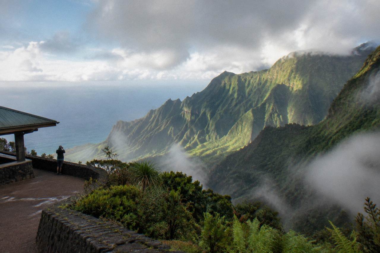 Green Kauai valley ridges under a mix of sun and passing clouds