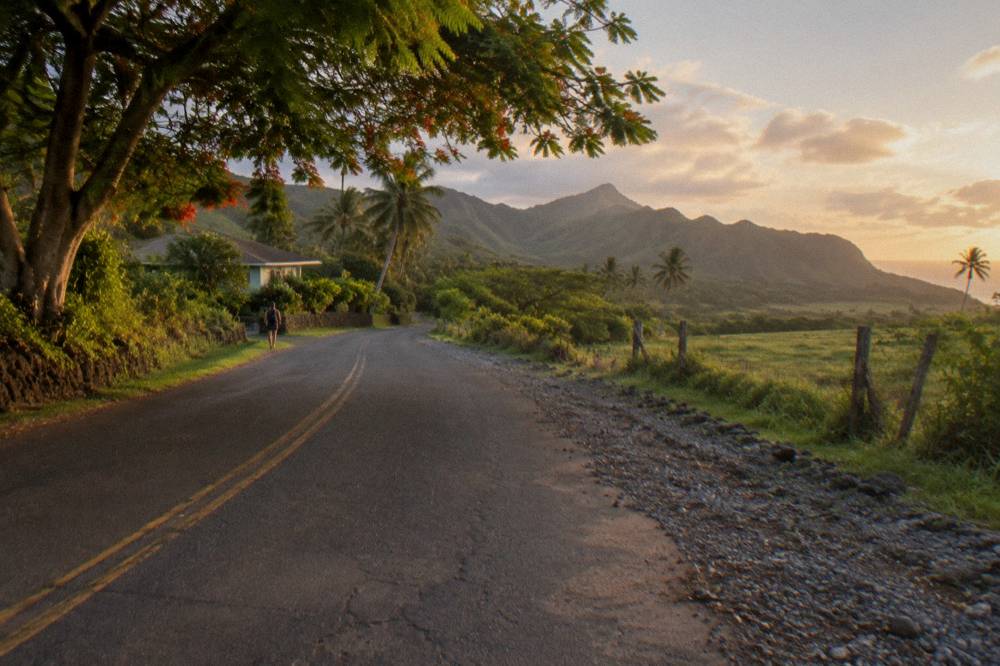A quiet Kauai valley road passing green hills and tropical trees